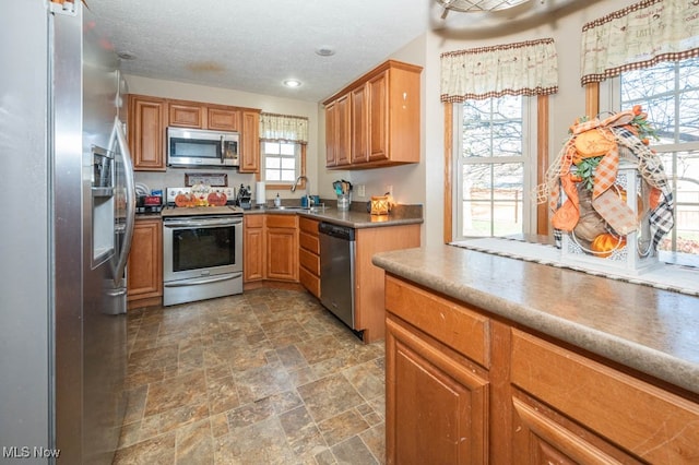 kitchen with stainless steel appliances, sink, and plenty of natural light