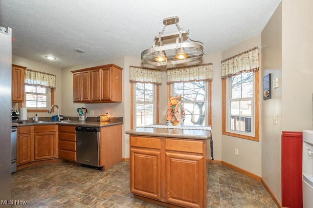 kitchen featuring dishwasher, pendant lighting, sink, and a textured ceiling