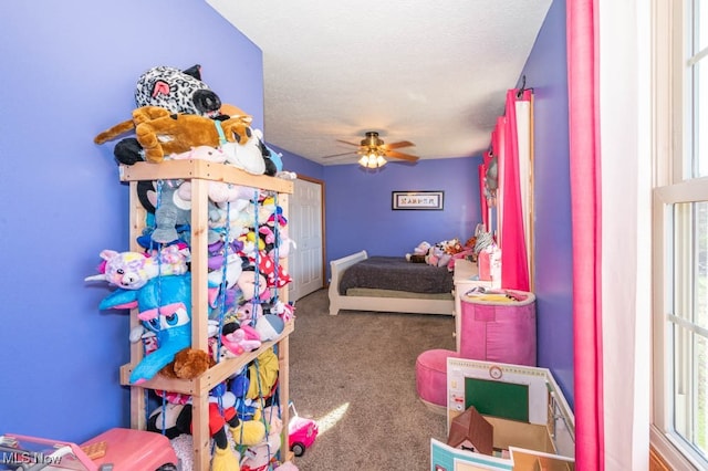 carpeted bedroom with a textured ceiling and ceiling fan