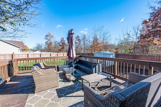 wooden deck with a storage shed and an outdoor hangout area