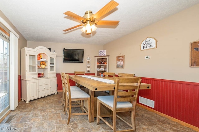 dining space with a textured ceiling and ceiling fan