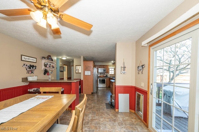 dining room featuring ceiling fan and a textured ceiling