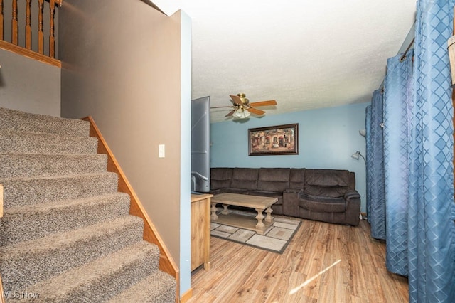 stairs with wood-type flooring and ceiling fan