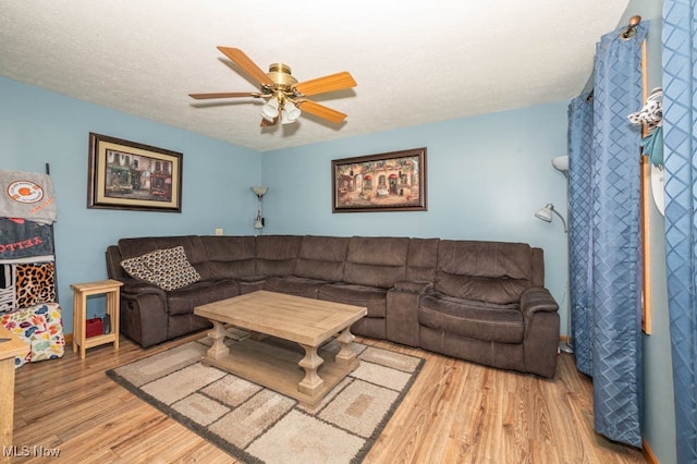 living room with a textured ceiling, hardwood / wood-style flooring, and ceiling fan