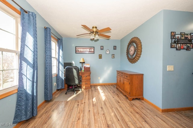 home office featuring light hardwood / wood-style flooring, lofted ceiling, and ceiling fan