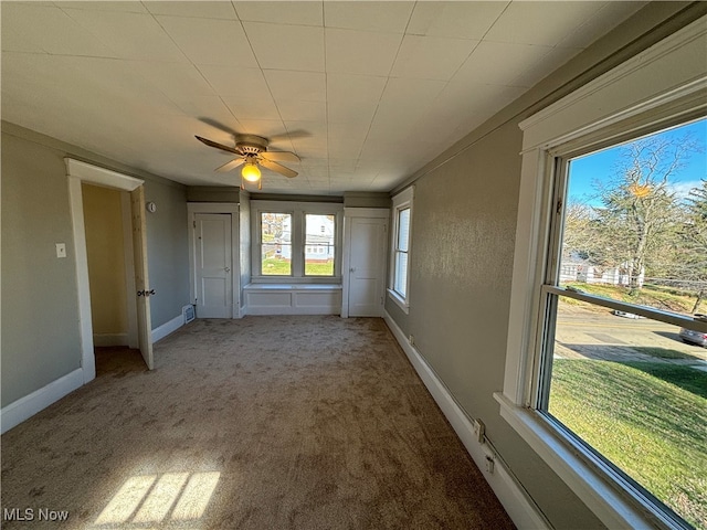 carpeted spare room featuring ceiling fan