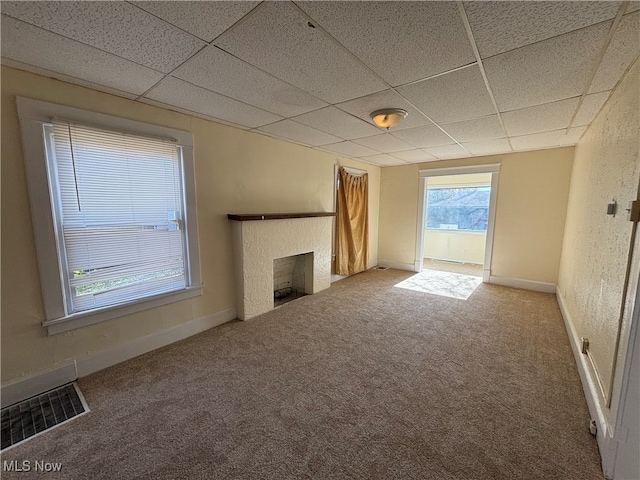 unfurnished living room featuring a drop ceiling and carpet floors