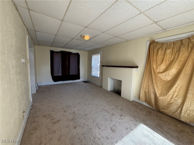 basement with a drop ceiling and light colored carpet