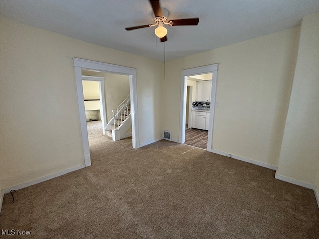 carpeted spare room with ceiling fan