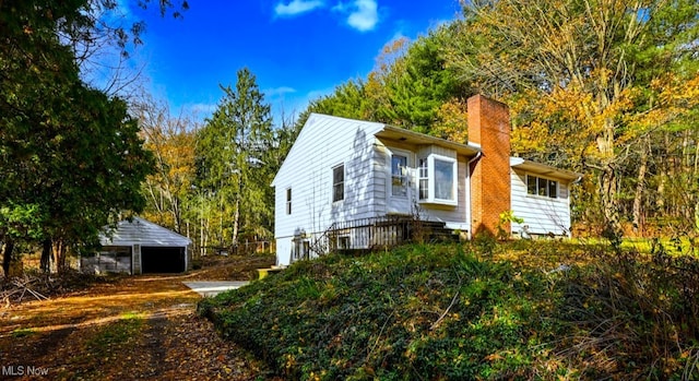 view of side of property with a garage and an outbuilding