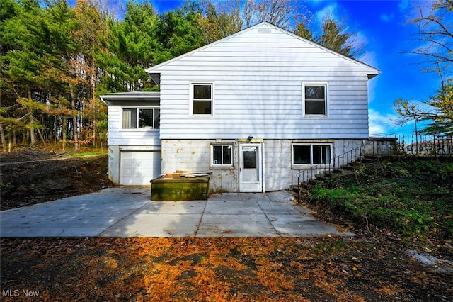 back of house with a garage and a patio area