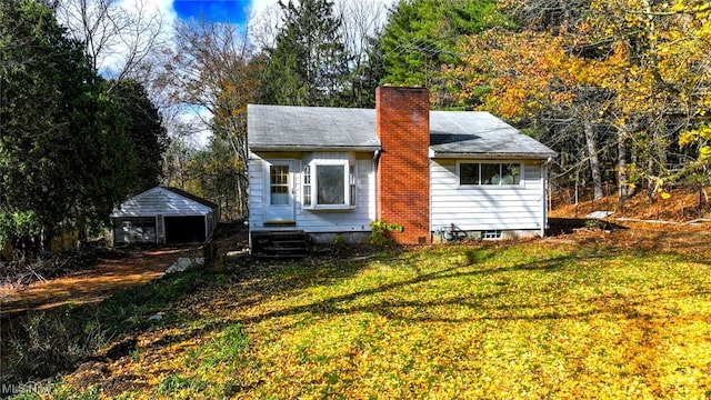 back of property with a shed and a lawn