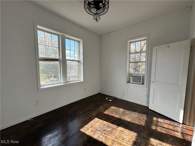 unfurnished room featuring cooling unit and dark hardwood / wood-style floors