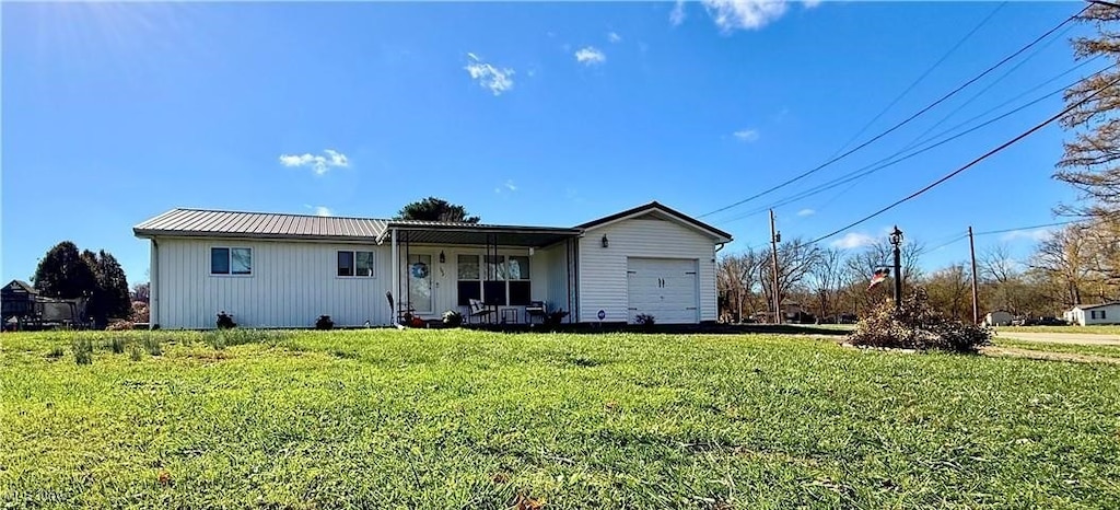 view of front of home with a porch, a front lawn, and a garage