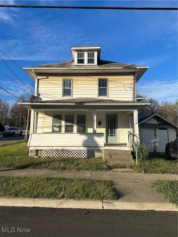 view of front of house with a porch and a storage shed