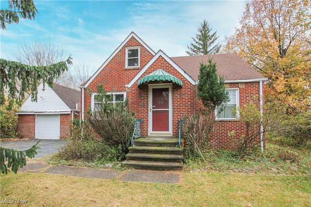 view of front of house featuring a front lawn, a garage, and an outdoor structure