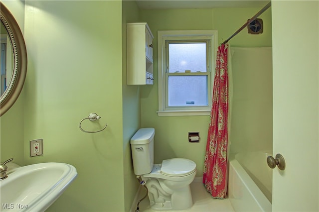 full bathroom featuring sink, shower / bathtub combination with curtain, and toilet