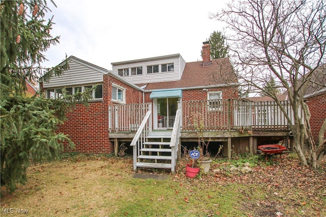 back of house featuring a sunroom, a lawn, and a wooden deck