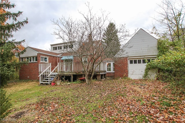 back of property with a garage and a wooden deck