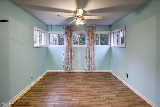 spare room with hardwood / wood-style floors and ceiling fan