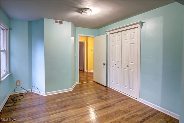 unfurnished bedroom featuring dark wood-type flooring and a closet