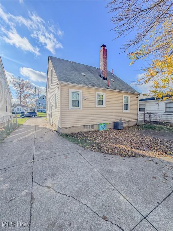 1330 W 18th St, Lorain, OH 44052 - rear view of house featuring a chimney, driveway, and central AC unit