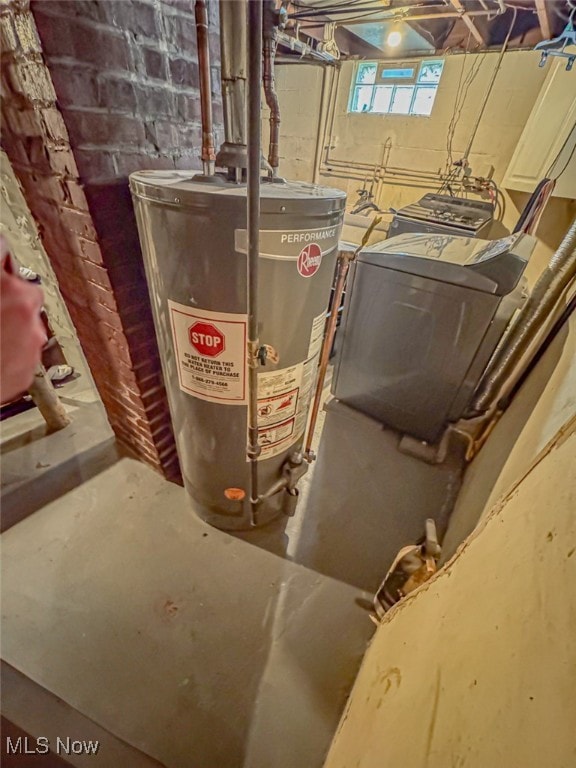 utility room with water heater and washer / dryer