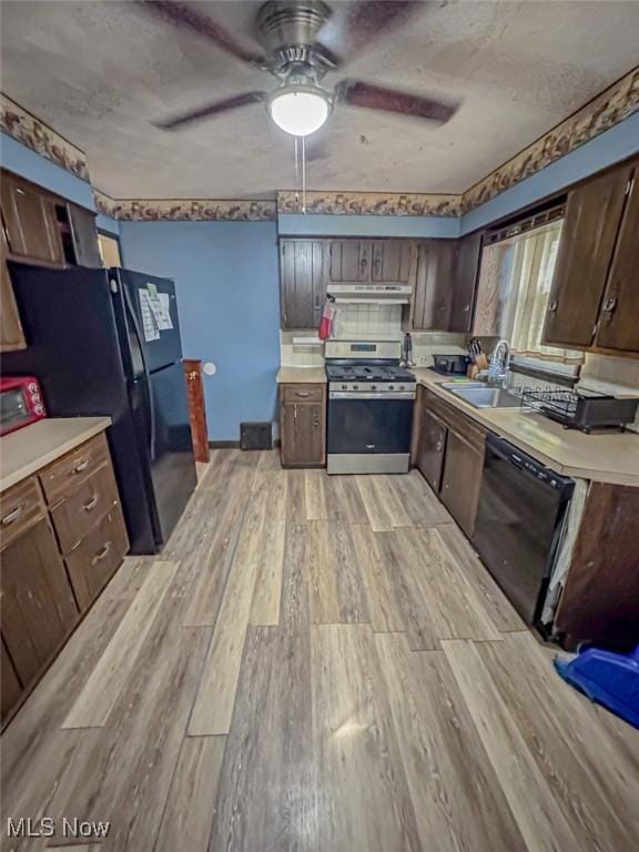 1330 W 18th St, Lorain, OH 44052 - kitchen with black appliances, a sink, light wood-type flooring, light countertops, and a ceiling fan