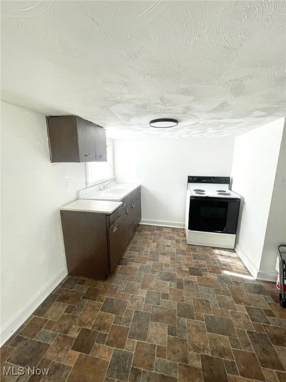 kitchen featuring dark brown cabinets and white electric stove