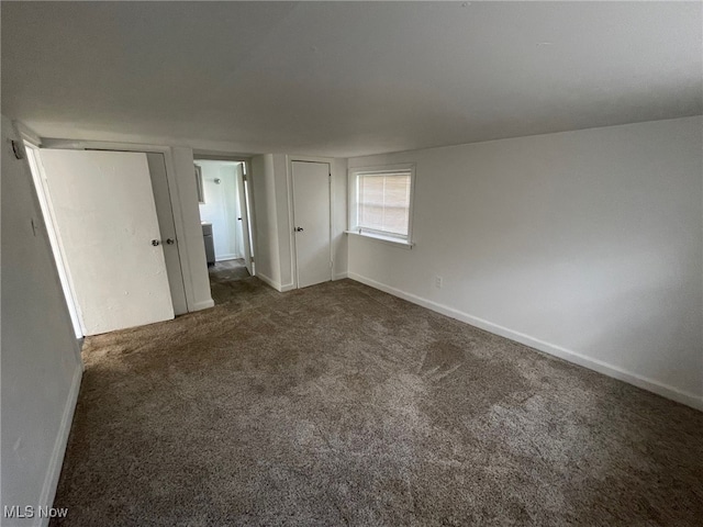 unfurnished bedroom with dark carpet