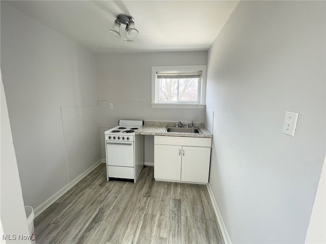 kitchen with white cabinetry, light hardwood / wood-style floors, sink, and white stove