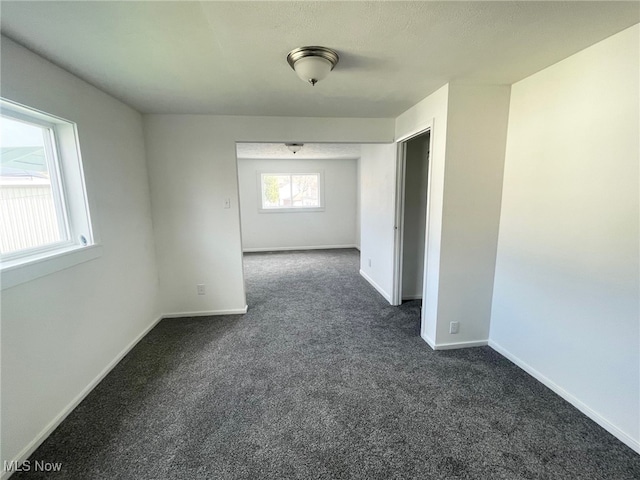 unfurnished room featuring dark carpet