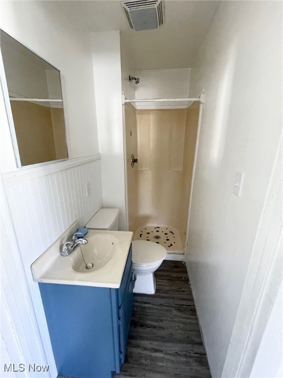 bathroom with walk in shower, vanity, toilet, and hardwood / wood-style floors