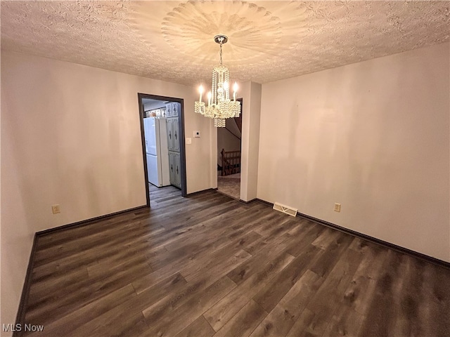 unfurnished dining area with a textured ceiling, dark hardwood / wood-style flooring, and a notable chandelier