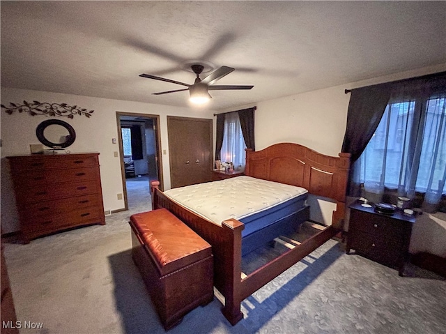 bedroom with ceiling fan, carpet, and a textured ceiling