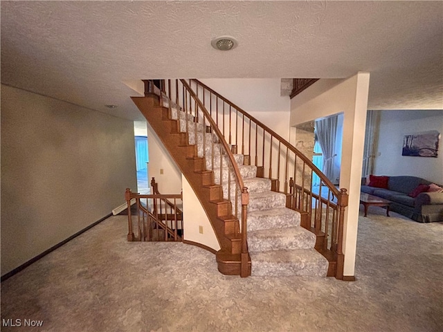 staircase with concrete flooring and a textured ceiling