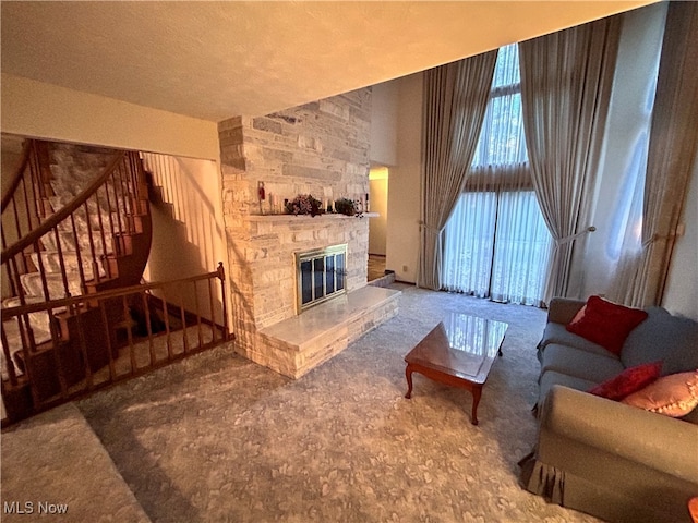 living room with a stone fireplace and carpet floors