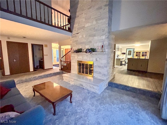 living room with a high ceiling, a fireplace, and carpet flooring