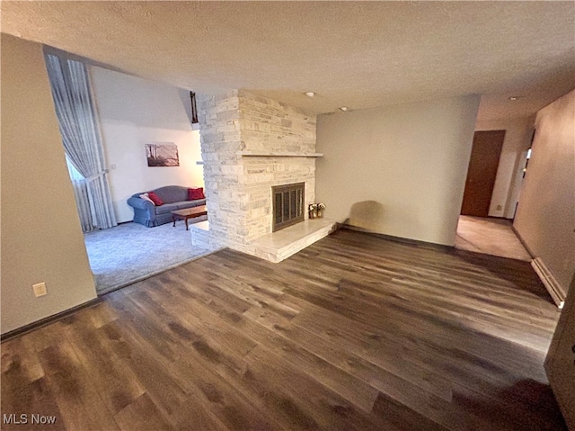 unfurnished living room with a fireplace, a textured ceiling, and hardwood / wood-style flooring