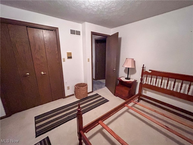 carpeted bedroom featuring a closet and a textured ceiling