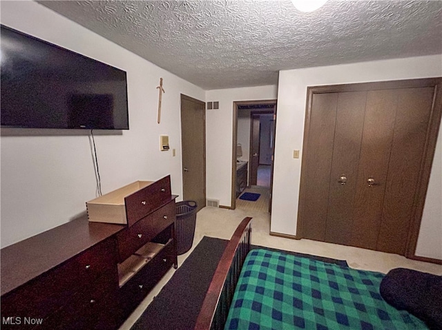 carpeted bedroom with a closet and a textured ceiling