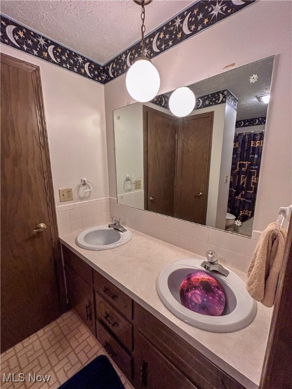 bathroom featuring a textured ceiling, vanity, and toilet