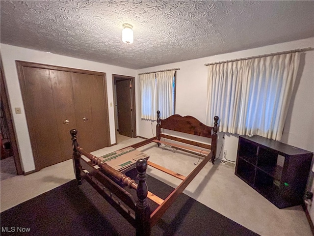 bedroom featuring a closet, light colored carpet, and a textured ceiling