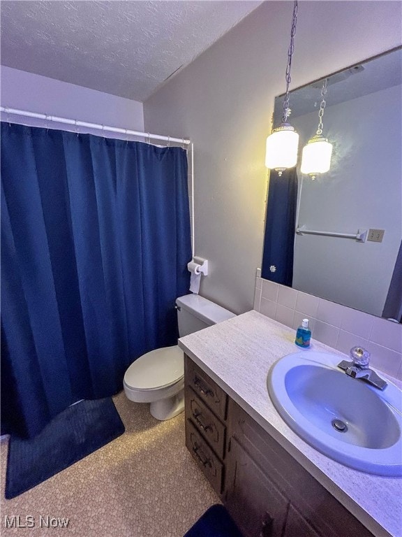 bathroom featuring vanity, a textured ceiling, and toilet