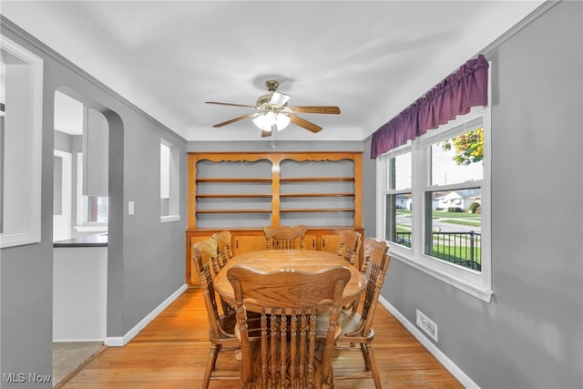 dining space with ceiling fan and light wood-type flooring