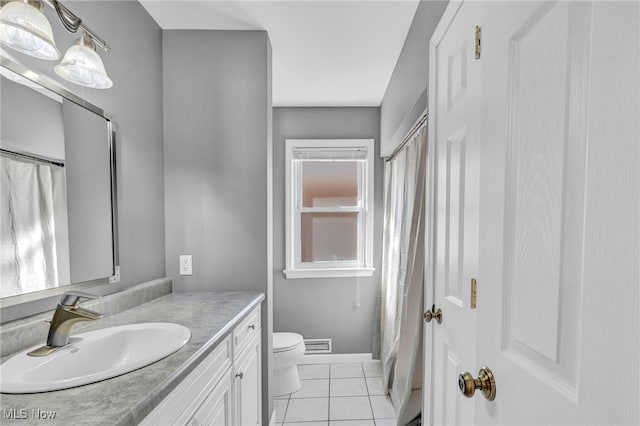 bathroom with vanity, tile patterned floors, and toilet