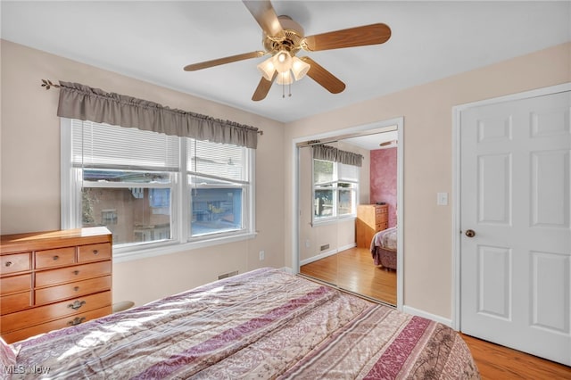 bedroom featuring ceiling fan, a closet, and light wood-type flooring