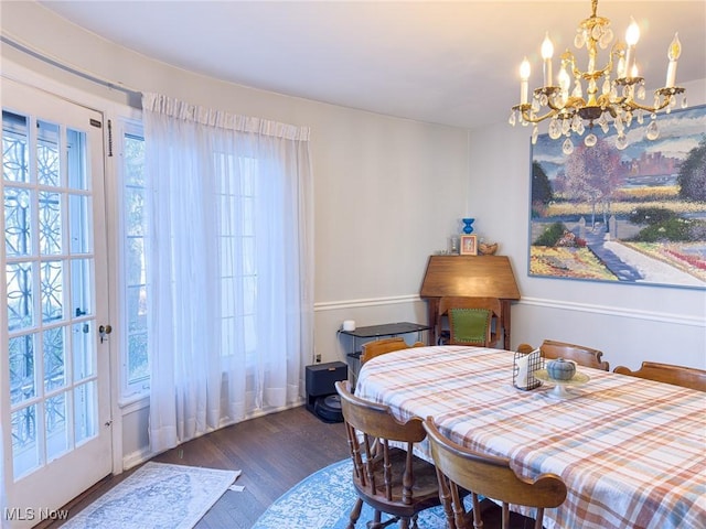 dining room featuring an inviting chandelier and dark wood-type flooring