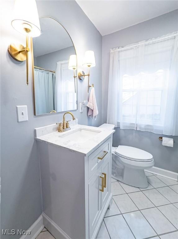 bathroom featuring tile patterned flooring, vanity, and toilet