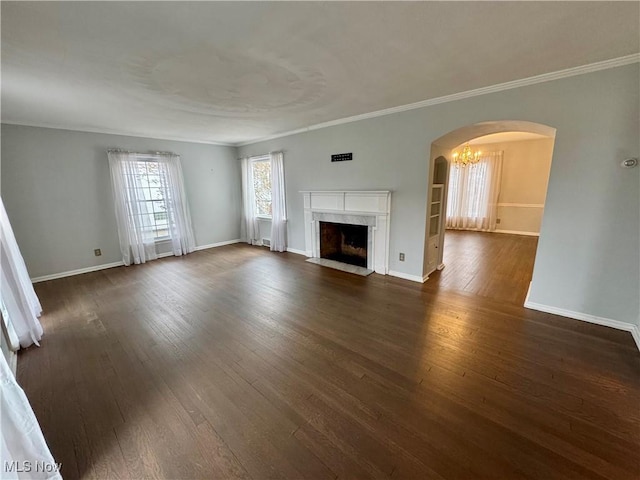 unfurnished living room featuring a high end fireplace, a chandelier, dark hardwood / wood-style floors, and ornamental molding